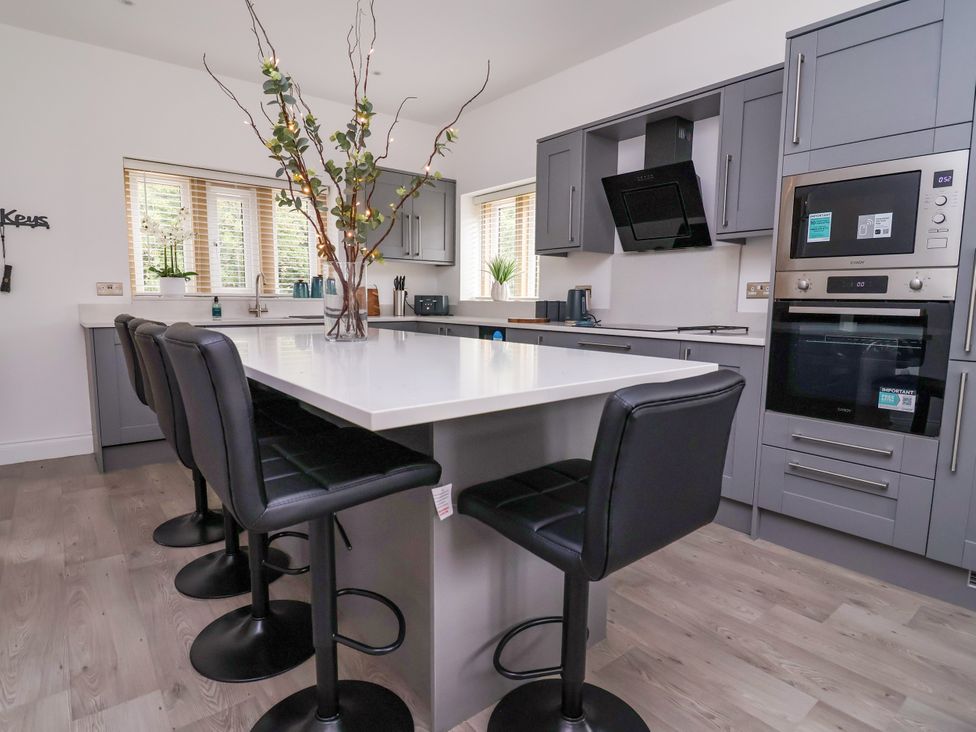 A kitchen with bar stools and appliances at Greenfield Manor near Greenfield