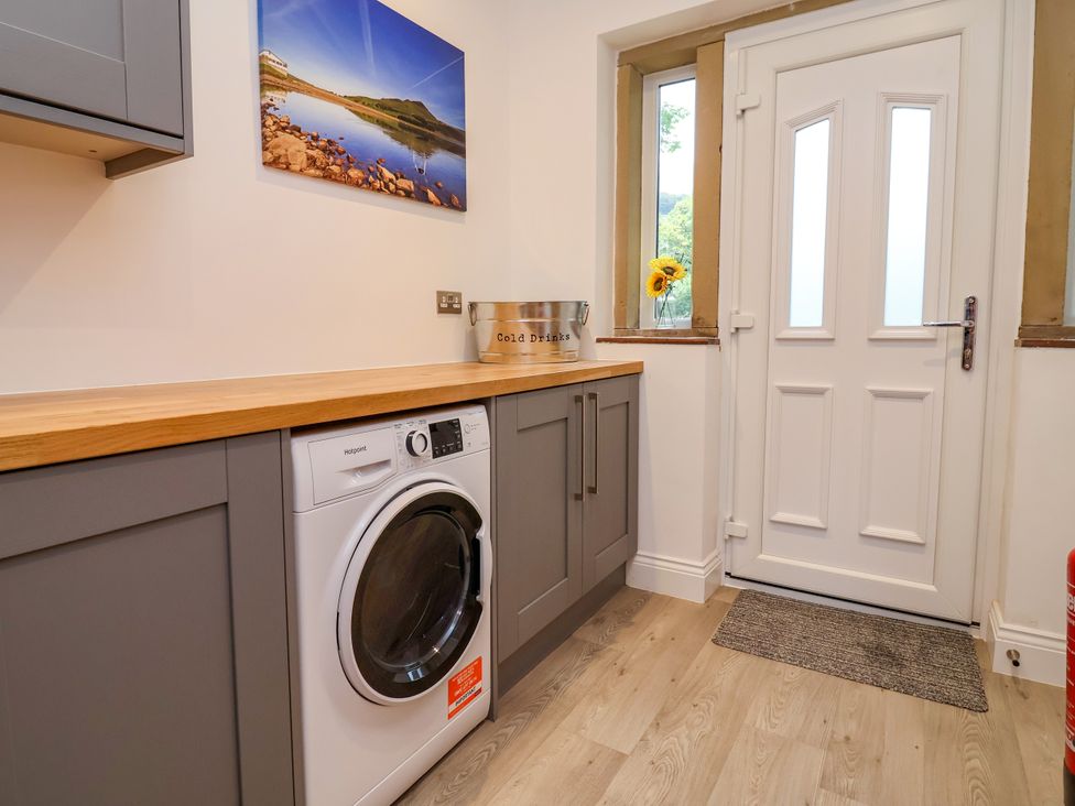 A laundry room with washing machine and countertop at Greenfield Manor near Greenfield