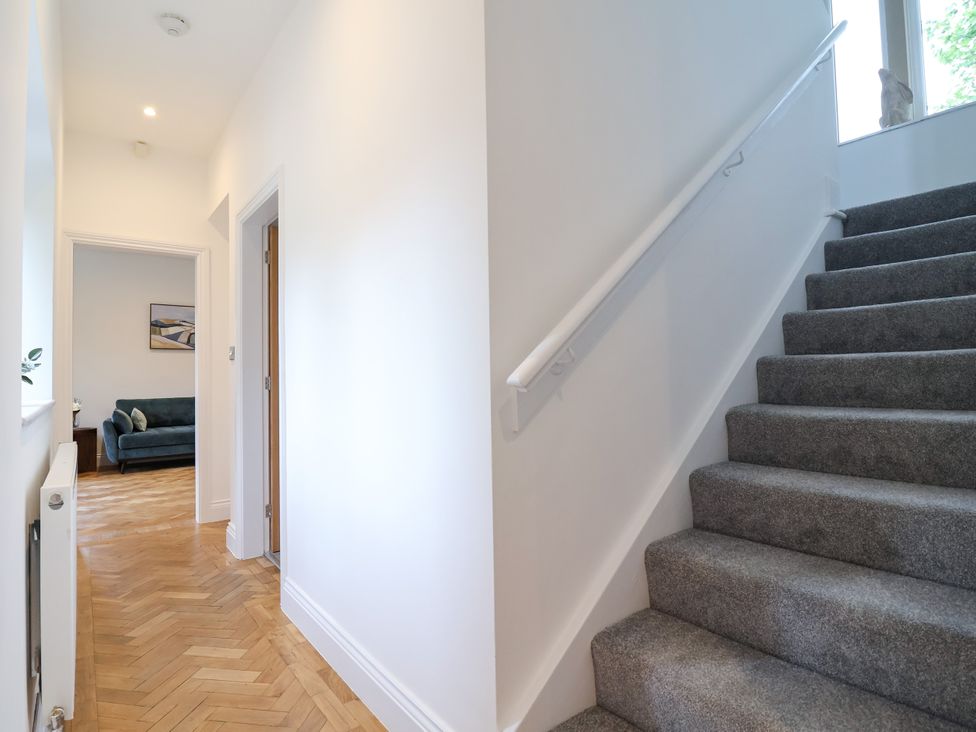 A hallway with stairs and a couch visible at Greenfield Manor near Greenfield