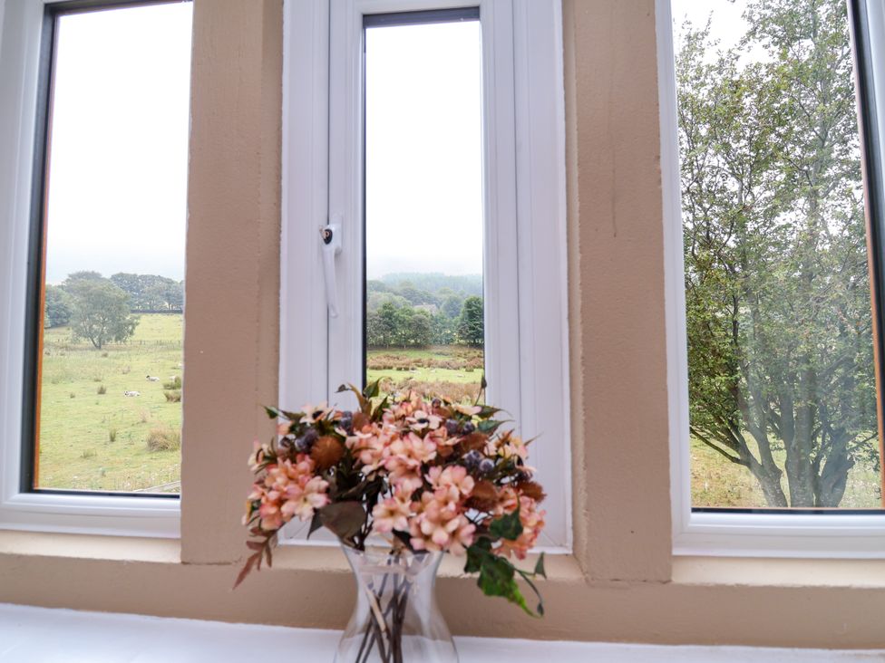 A window with flowers in a vase at Greenfield Manor near Greenfield