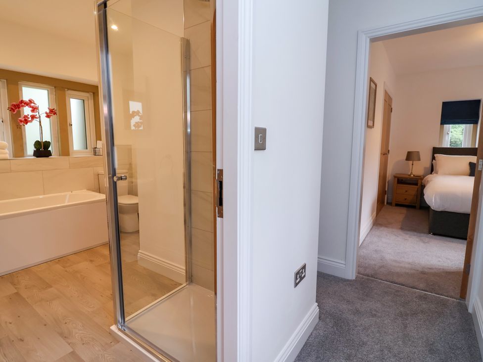 A bathroom with a shower and bathtub at Greenfield Manor near Greenfield