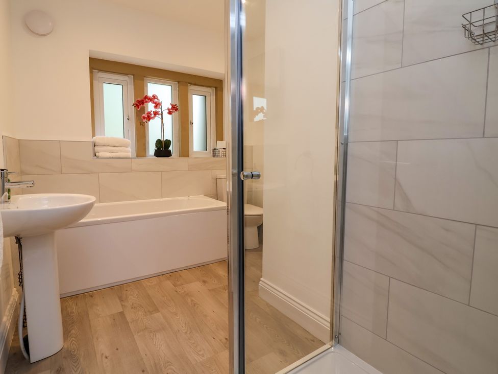 A bathroom with a bath tub and shower at Greenfield Manor near Greenfield