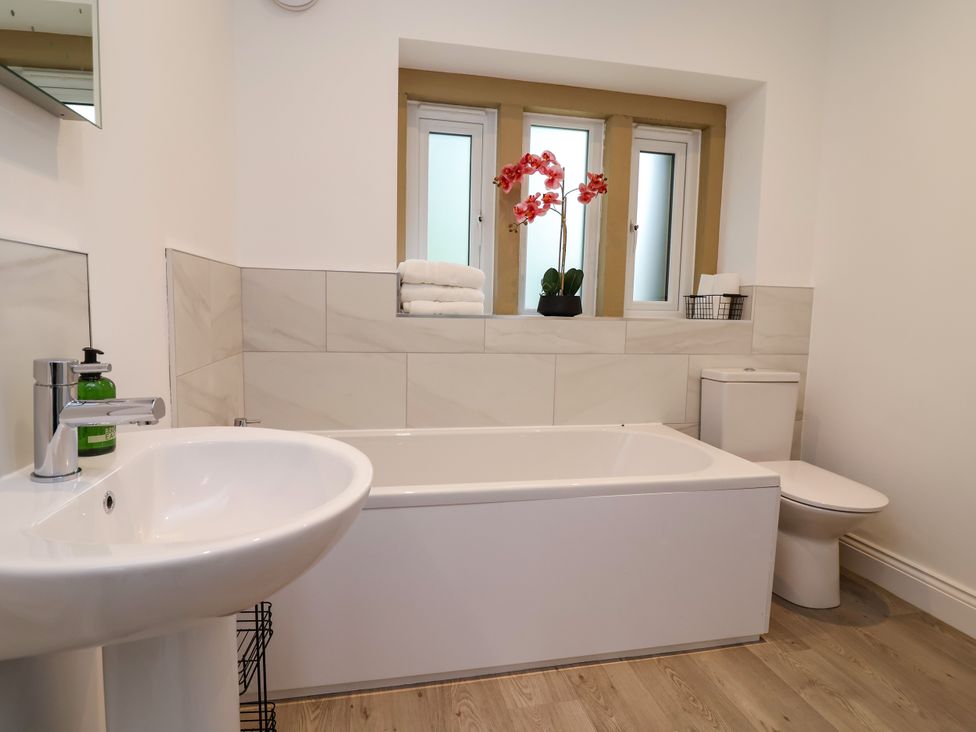 A bathroom with a bathtub, sink, and toilet at Greenfield Manor near Greenfield