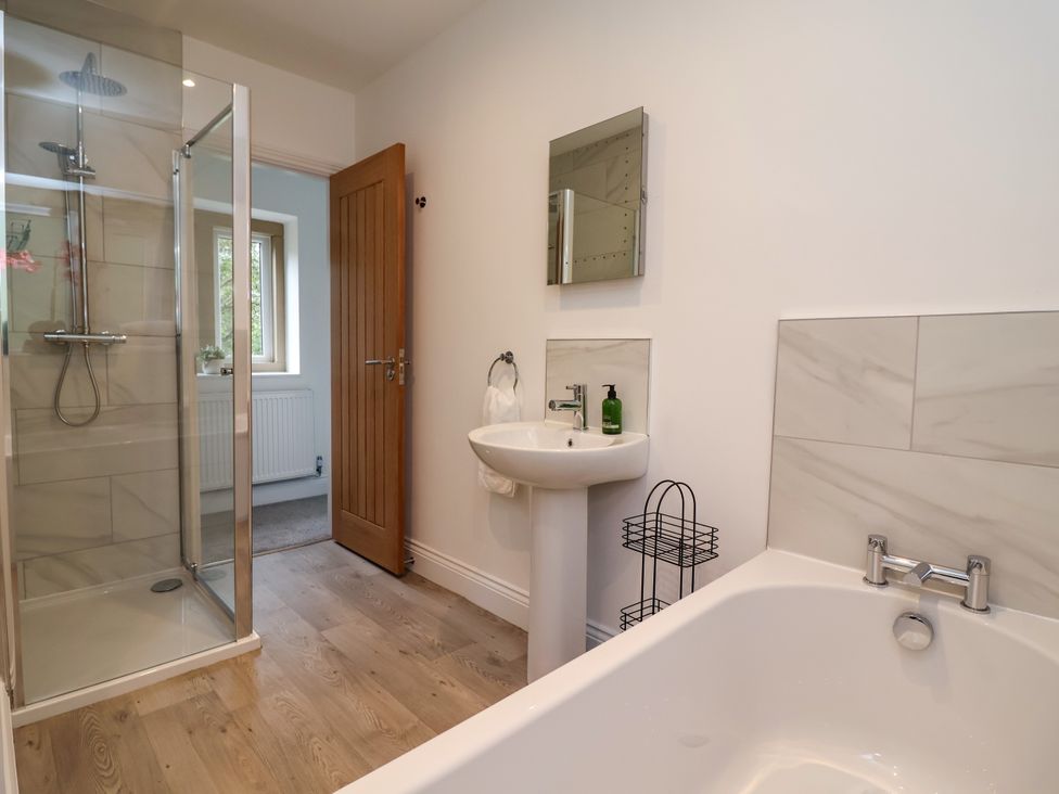 A bathroom with a shower, sink, and bathtub at Greenfield Manor near Greenfield