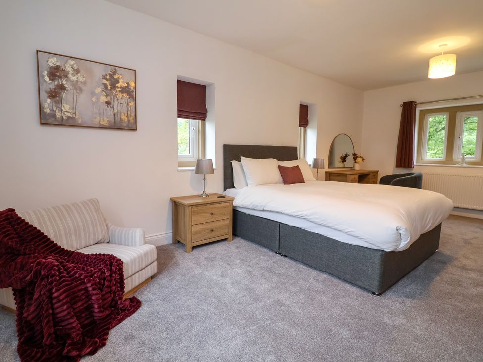 A bedroom with a bed, nightstand, and armchair at Greenfield Manor near Greenfield