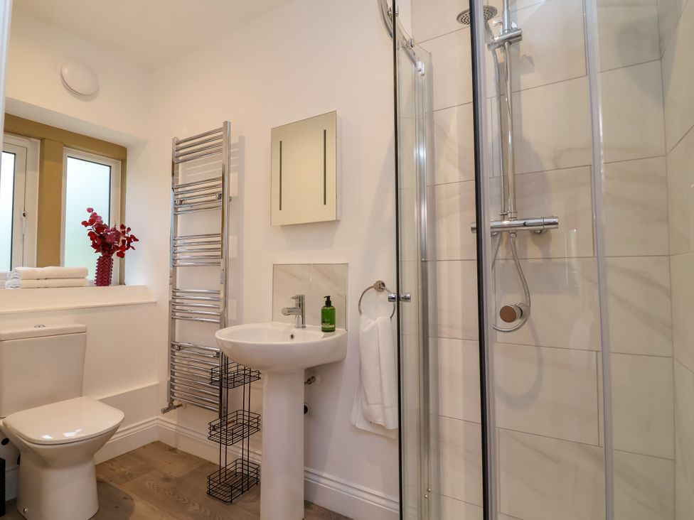 A bathroom with a shower, toilet, and sink at Greenfield Manor near Greenfield