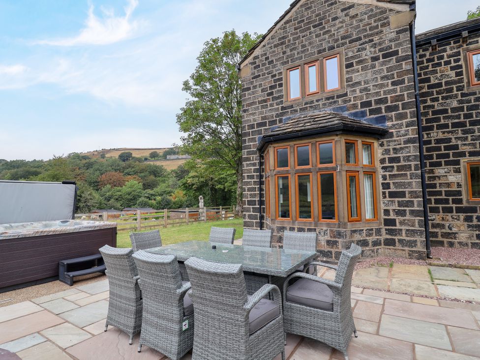An outdoor dining area with a hot tub at Greenfield Manor near Greenfield