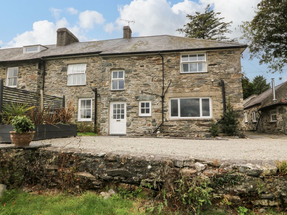 A stone building with windows and door at Ty Mawr Criccieth