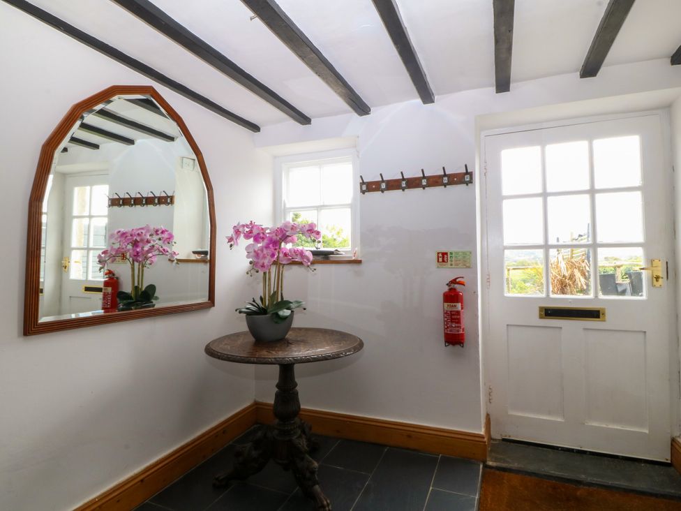 A hallway with a mirror and a table at Ty Mawr in Criccieth