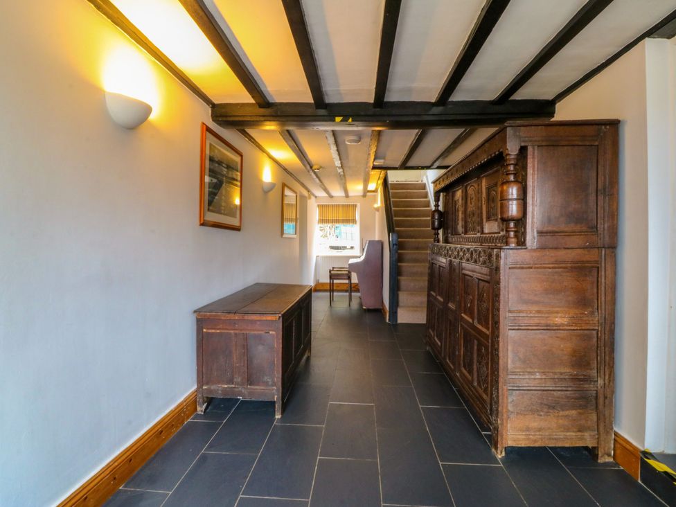 A hallway with a wooden bench and a staircase at Ty Mawr in Criccieth