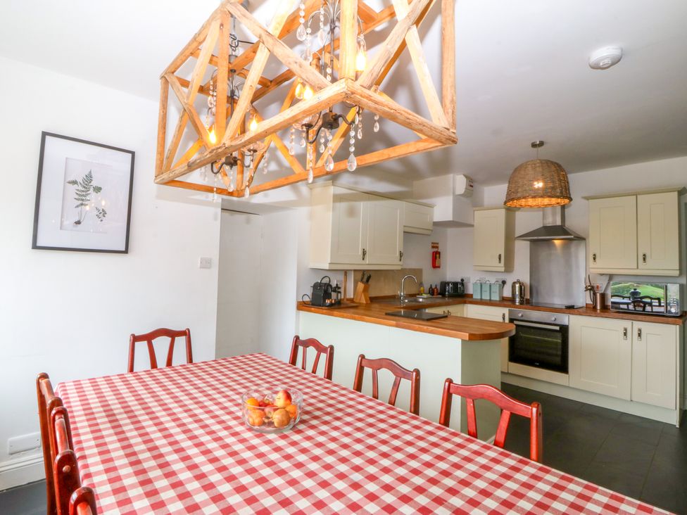 A kitchen with a dining table and chairs at Ty Mawr Criccieth
