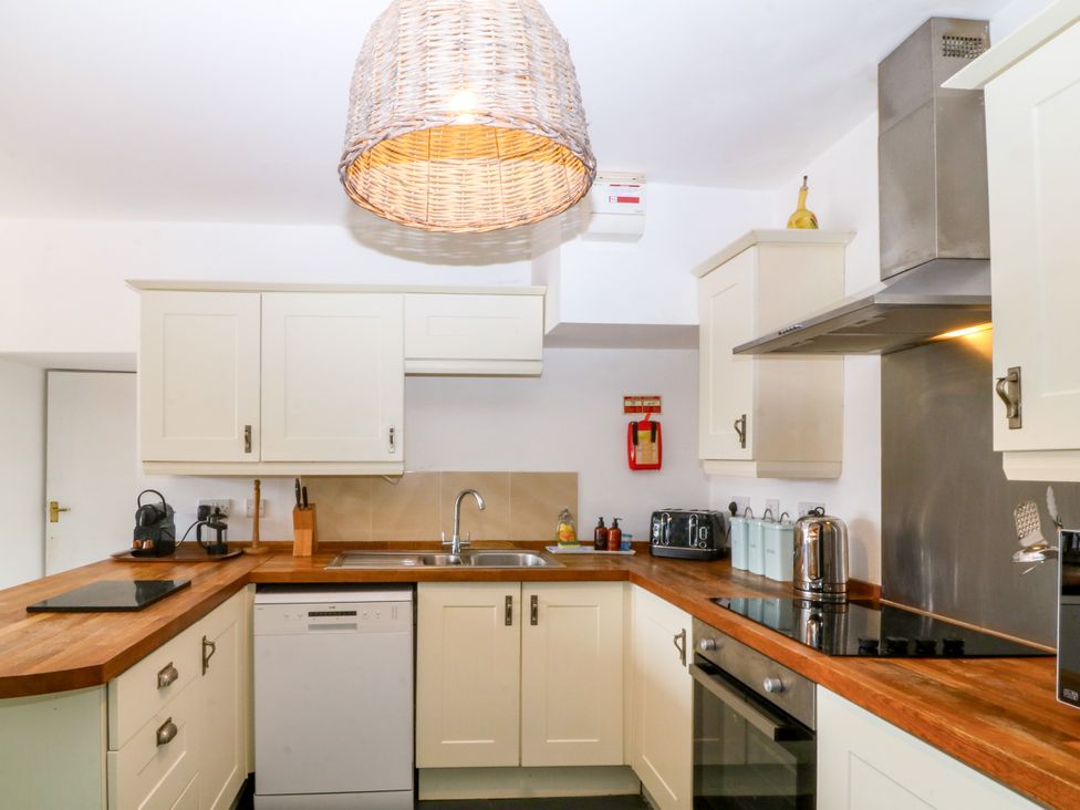 A kitchen with cabinets, sink, and appliances at Ty Mawr in Criccieth