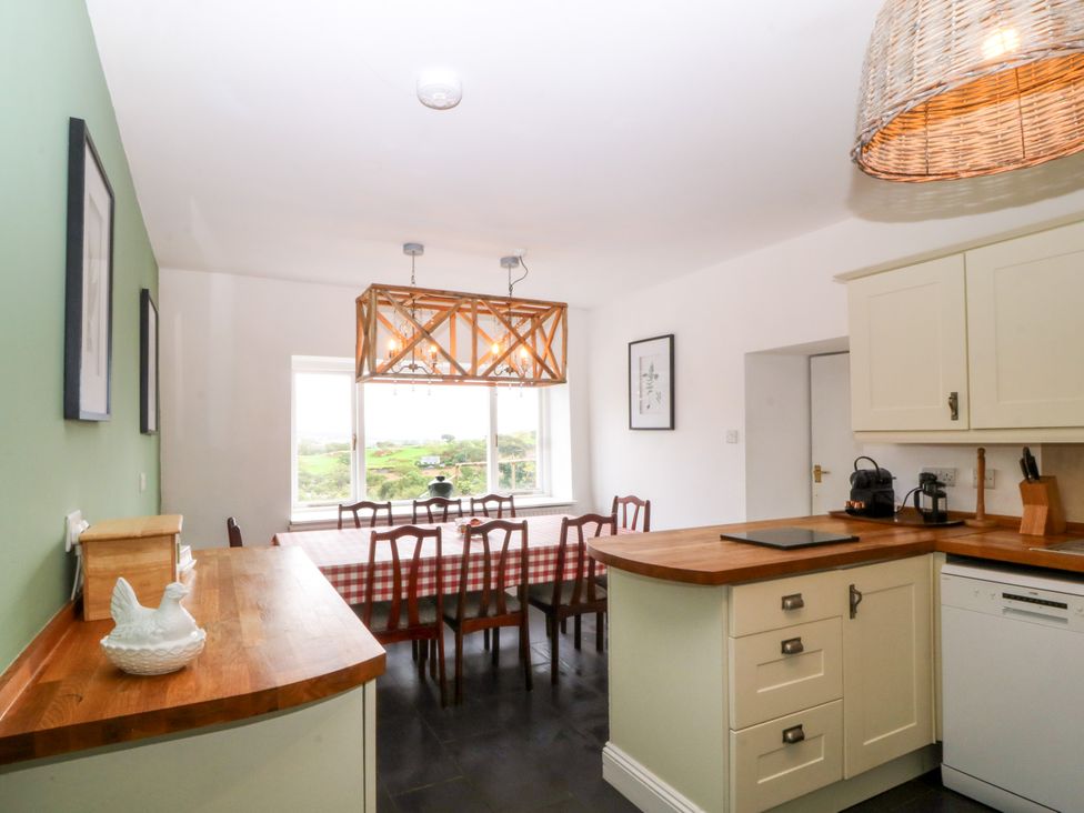 A kitchen with a dining table and chairs at Ty Mawr in Criccieth