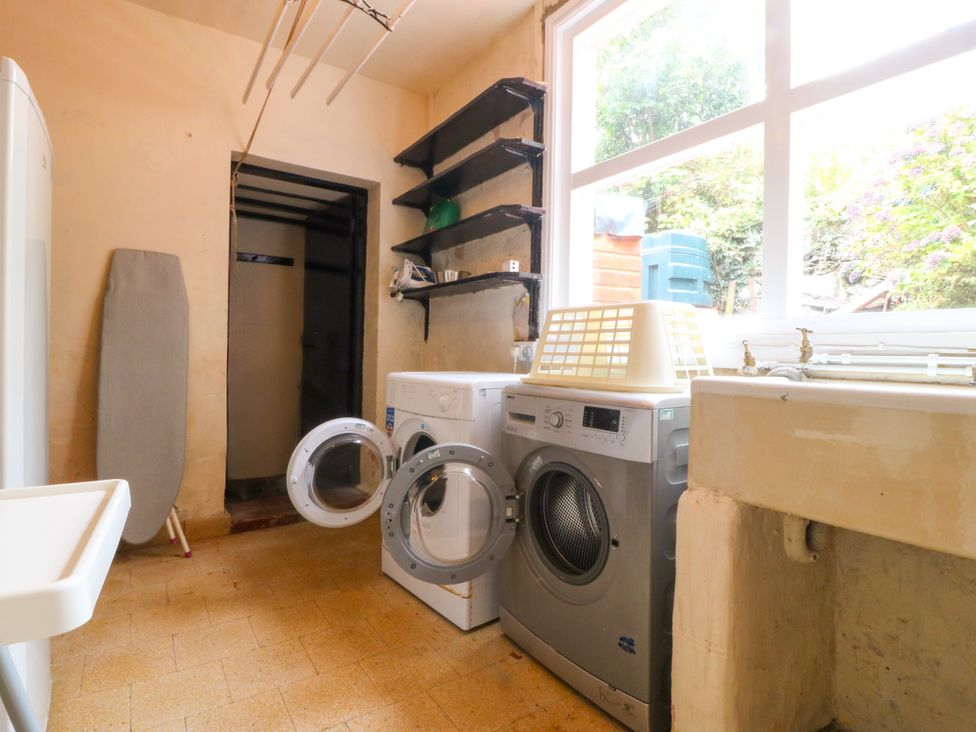 A laundry room with a washing machine and tumble dryer at Ty Mawr in Criccieth