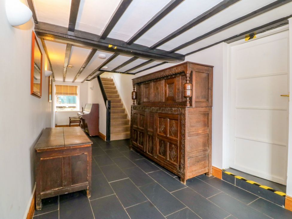 A hallway with a staircase and chest at Ty Mawr in Criccieth