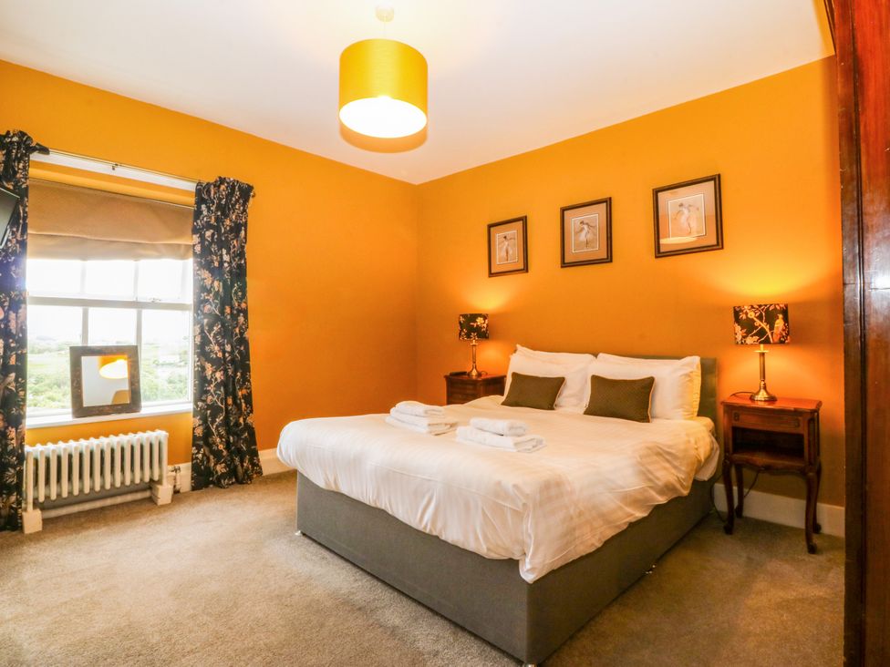A bedroom with a bed and curtains at Ty Mawr in Criccieth