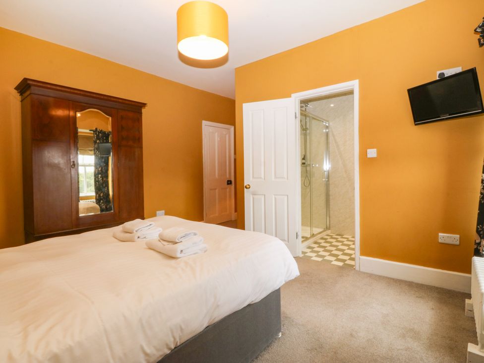 A bedroom with a bed and wardrobe at Ty Mawr in Criccieth