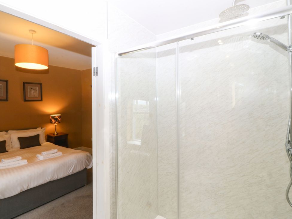 A bedroom with a bed and a shower at Ty Mawr in Criccieth