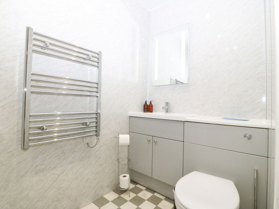 A bathroom with a sink, toilet, and towel rack at Ty Mawr in Criccieth