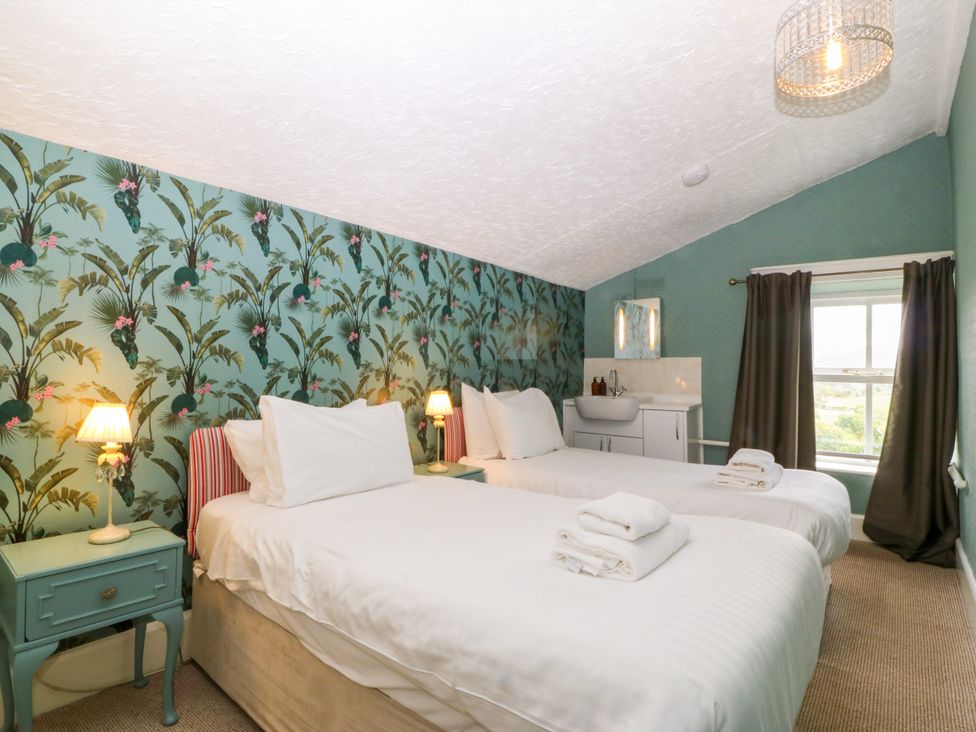 A bedroom with two beds and a sink at Ty Mawr in Criccieth