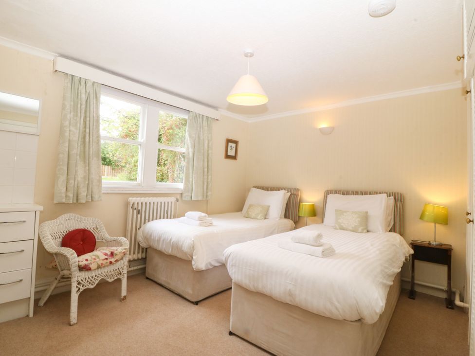 A bedroom with two beds and a chair at Ty Mawr in Criccieth