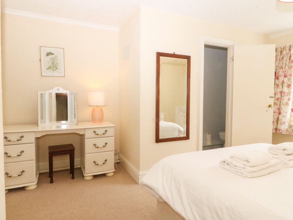 A bedroom with a bed and vanity at Ty Mawr in Criccieth