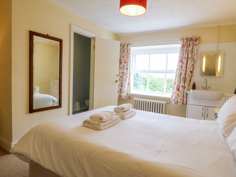 A bedroom with a bed and a sink at Ty Mawr in Criccieth