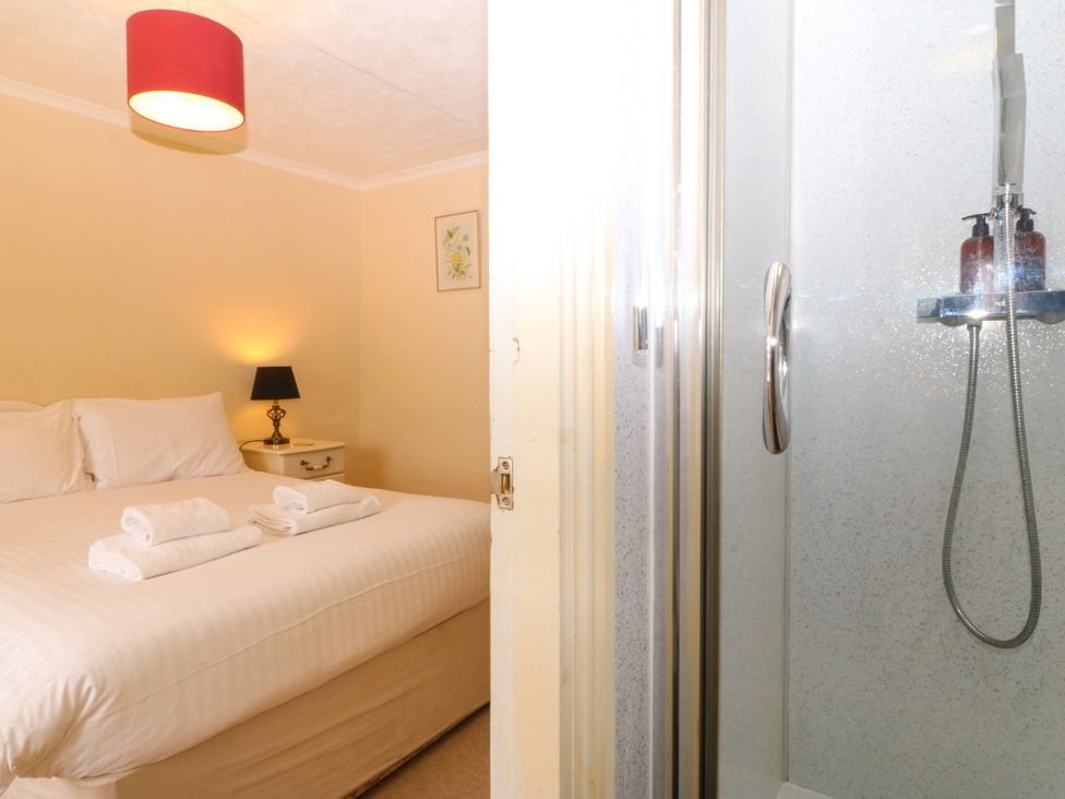 A bedroom with a bed and shower visible at Ty Mawr in Criccieth
