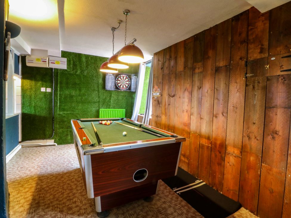 A game room with a pool table and a dartboard at Ty Mawr in Criccieth