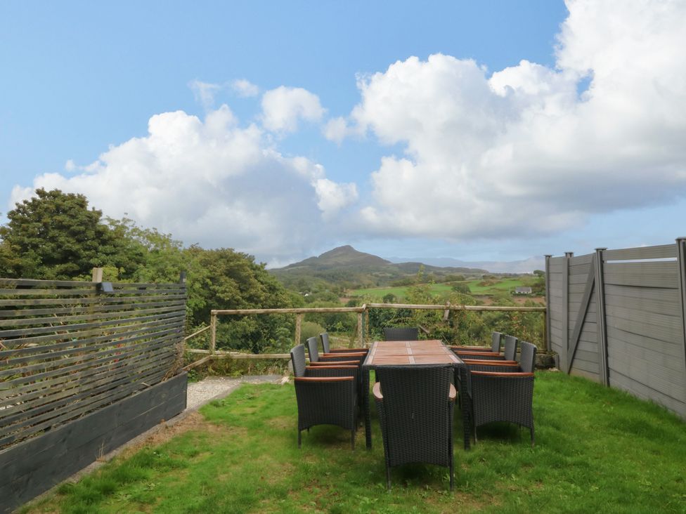 A garden with a dining table and chairs at Ty Mawr in Criccieth