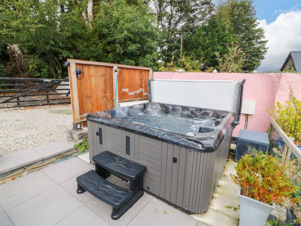 A hot tub with steps in an outdoor area at Ty Mawr Criccieth