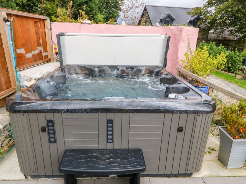 A hot tub with a step in an outdoor area at Ty Mawr in Criccieth