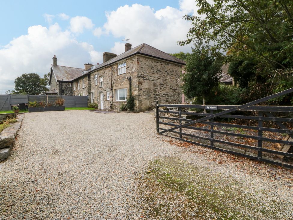 An outdoor area with a stone house and gravel driveway at Ty Mawr Criccieth