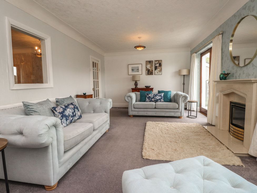 A living room with sofas and a fireplace at Nampara in Colwyn Bay