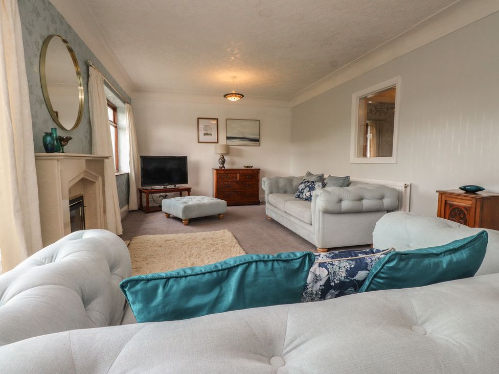 A living room with sofas and a TV at Nampara in Colwyn Bay