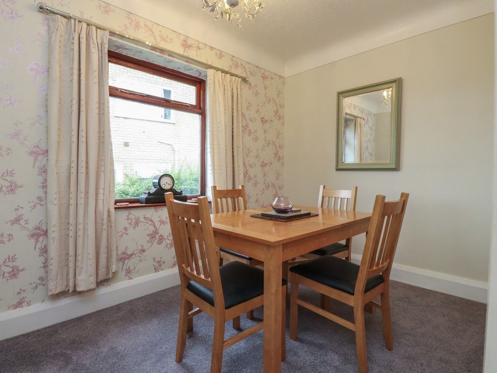 A dining room with a wooden table and chairs at Nampara in Colwyn Bay
