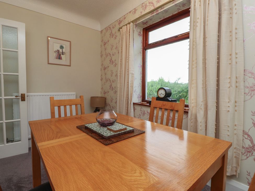 A dining room with a table and chairs at Nampara in Colwyn Bay