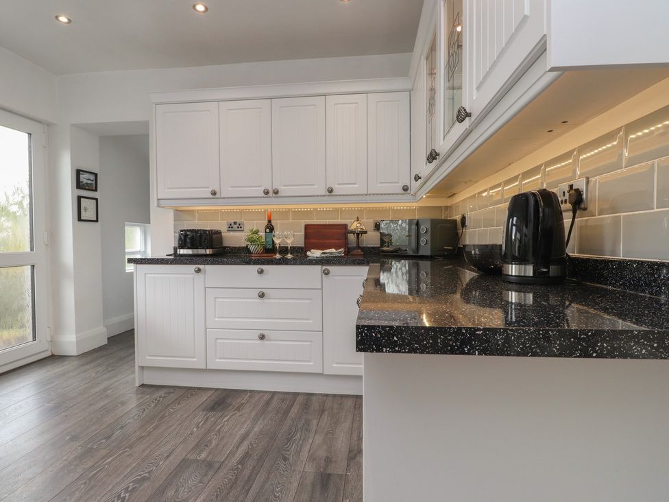 A kitchen with cabinets and appliances at Nampara in Colwyn Bay