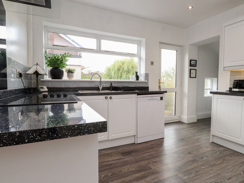 A kitchen with a sink and dishwasher at Nampara in Colwyn Bay
