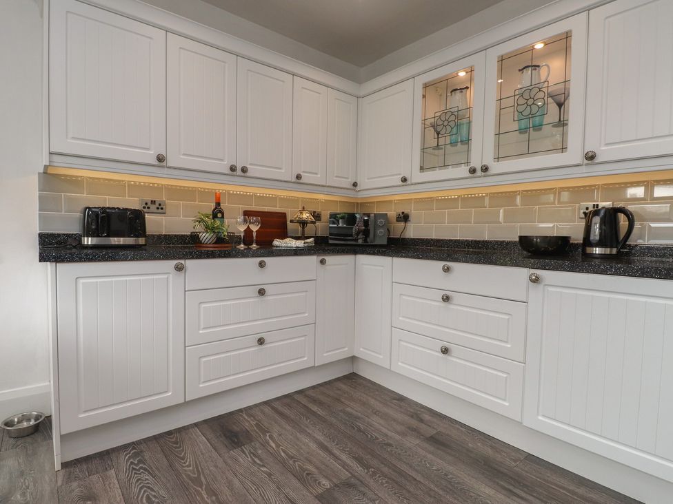A kitchen with cabinets and appliances at Nampara in Colwyn Bay