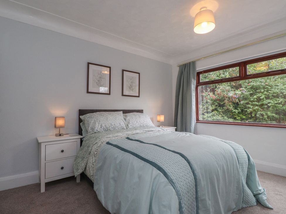 A bedroom with a bed and nightstand at Nampara in Colwyn Bay