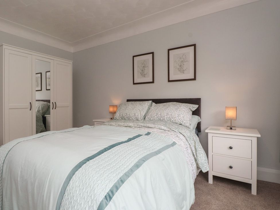 A bedroom with a bed and wardrobe at Nampara in Colwyn Bay