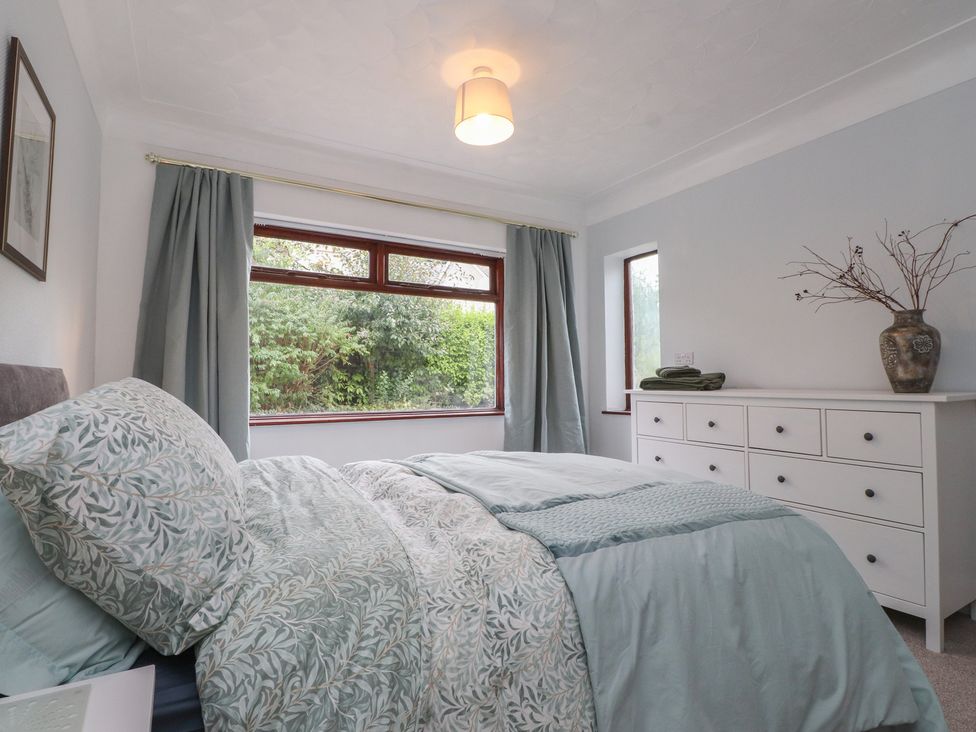 A bedroom with a bed and dresser at Nampara in Colwyn Bay