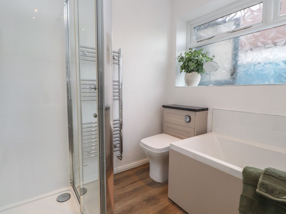A bathroom with a shower, bathtub, and toilet at Nampara in Colwyn Bay