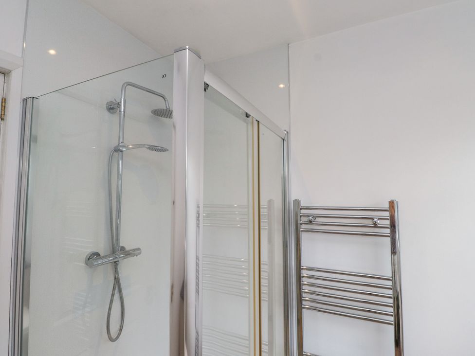 A bathroom featuring a shower and a towel radiator at Nampara in Colwyn Bay