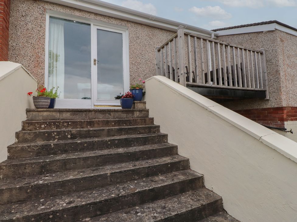 A set of stairs leading to a door with a balcony at Nampara in Colwyn Bay