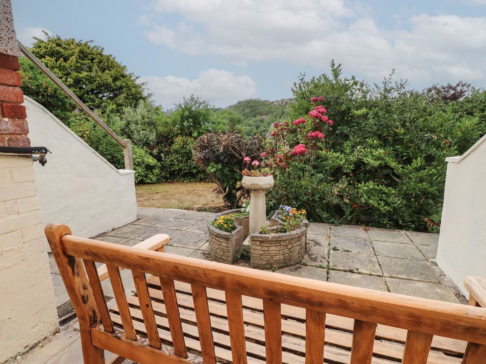 A garden with a bench and flowerbed at Nampara Colwyn Bay