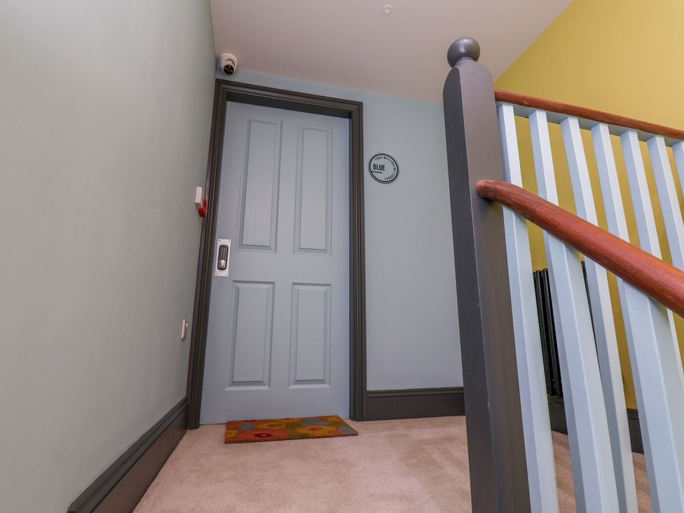 A hallway with a door and stairs at Apartment Blue in Whitby