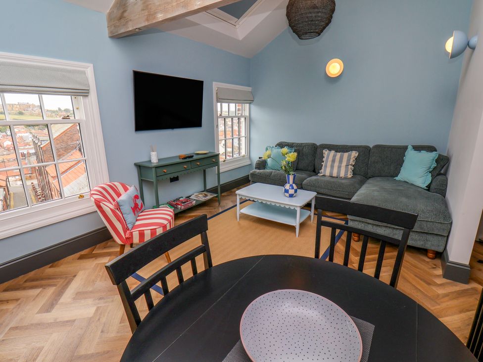 A living room with a sofa and television at Apartment Blue in Whitby