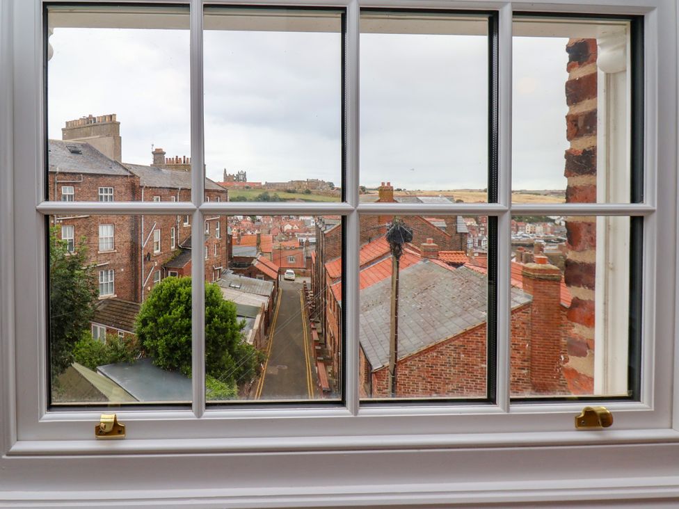 A view of rooftops and streets from a window at Apartment Blue in Whitby